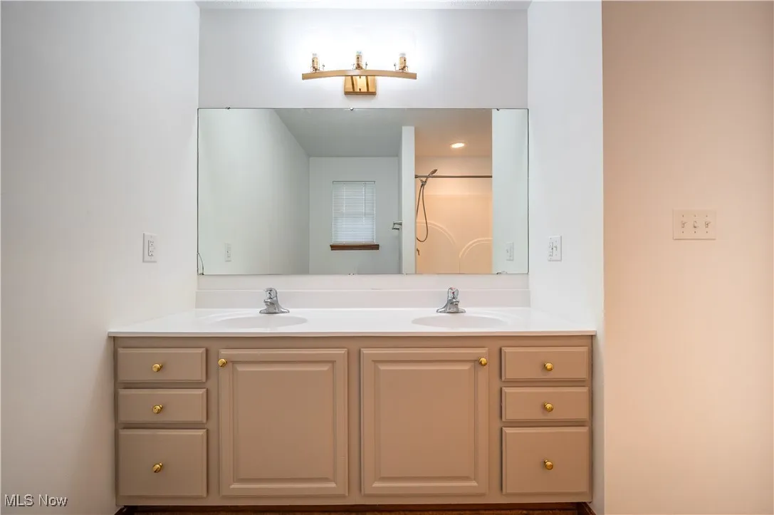 Full bathroom featuring double vanity and a shower