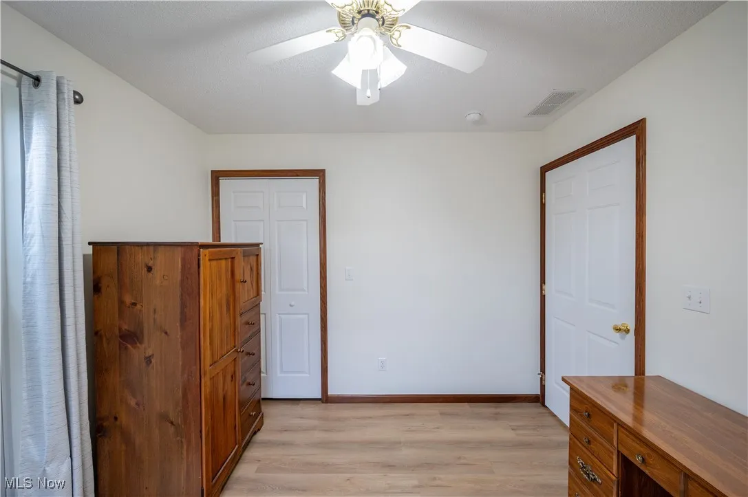 Unfurnished bedroom featuring light wood-type flooring and ceiling fan