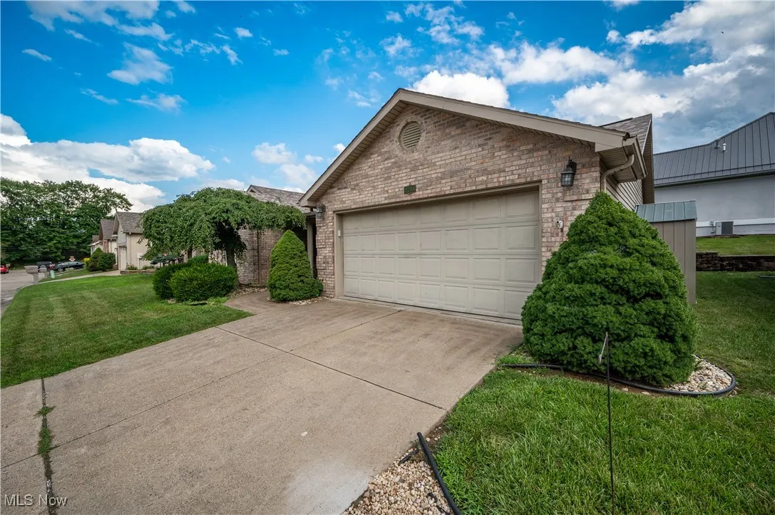 View of front of property featuring brick siding, a front lawn, and driveway