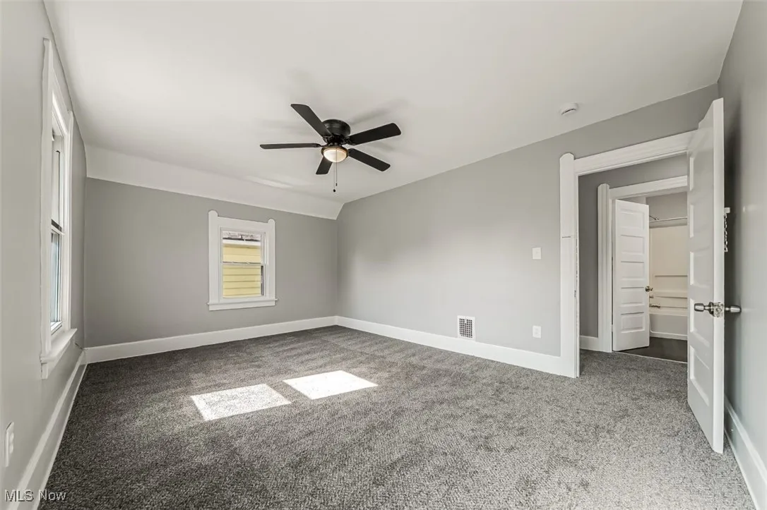 Unfurnished bedroom with light carpet and ceiling fan