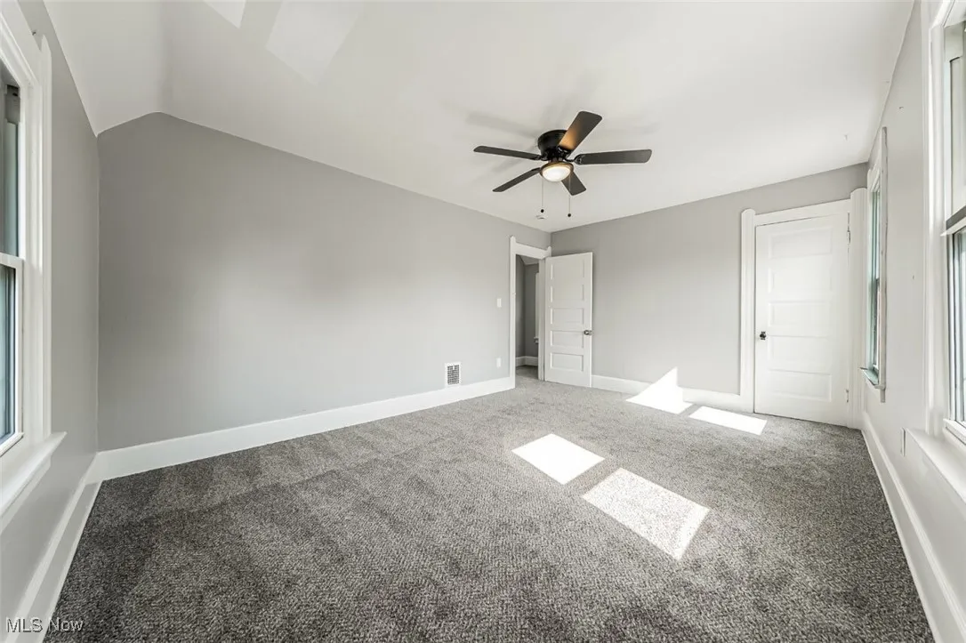 Unfurnished bedroom featuring carpet, ceiling fan, and a skylight