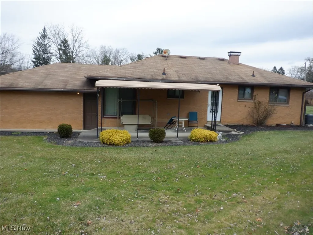 Back of house with a yard, a patio area, and central air condition unit