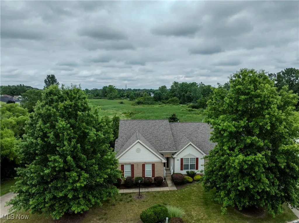 View of front of home with brick siding and a shingled roof