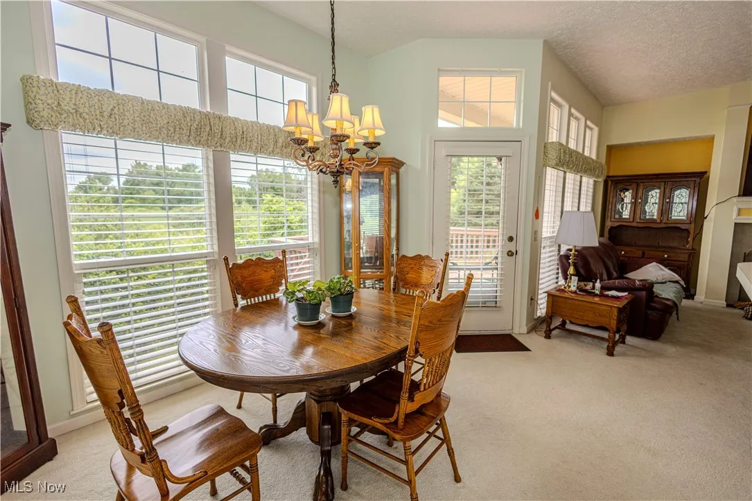 Dining area with light carpet and a chandelier