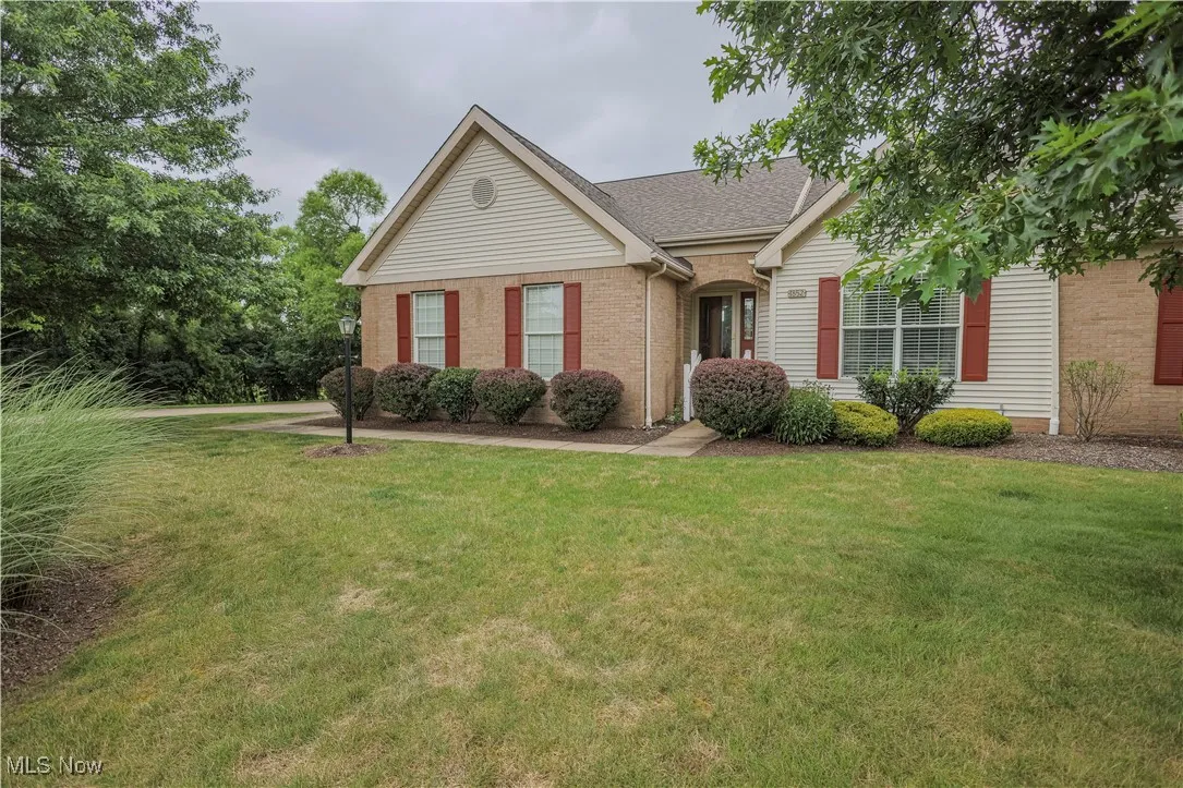 Single story home featuring a front lawn, brick siding, and a shingled roof