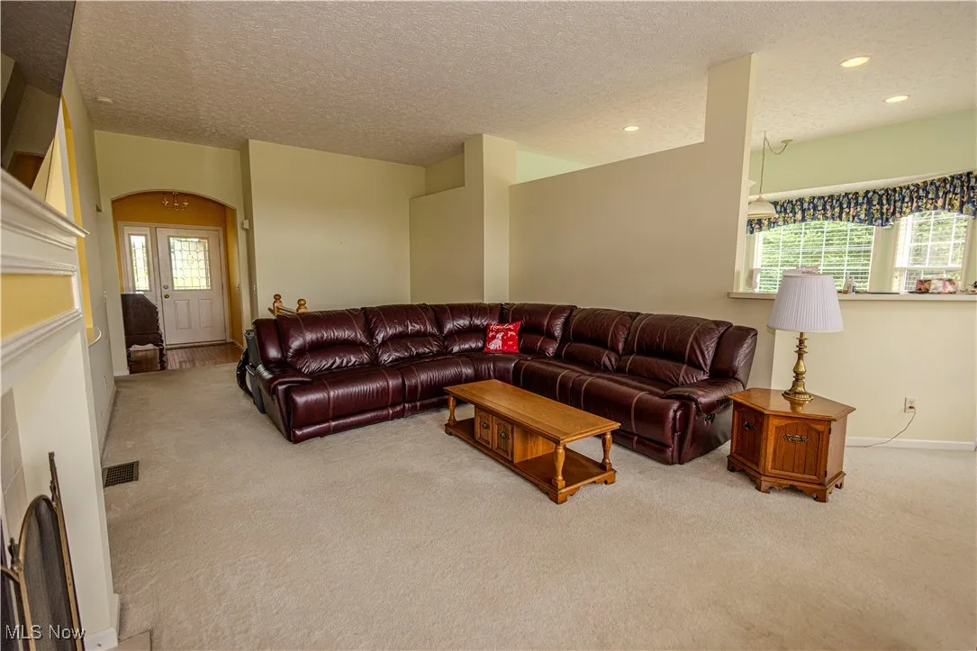 Carpeted living area featuring recessed lighting and a textured ceiling