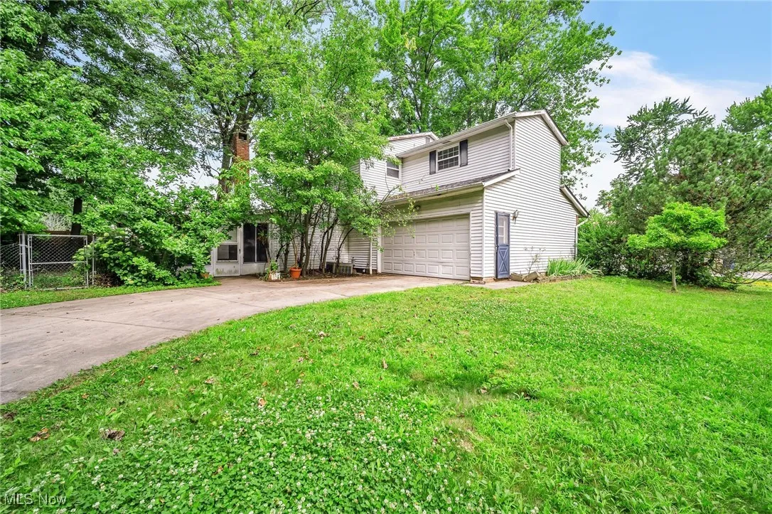View of front of home with concrete driveway, a garage, and a chimney