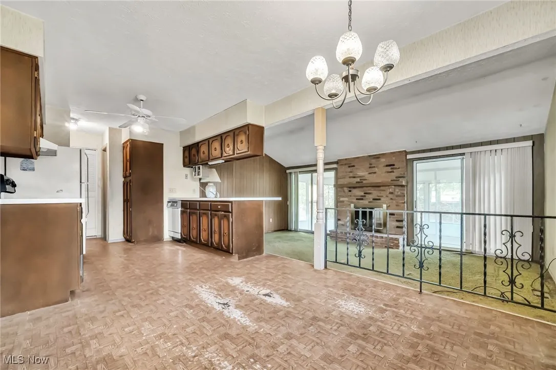 Kitchen featuring a ceiling fan, light countertops, a chandelier, and open floor plan