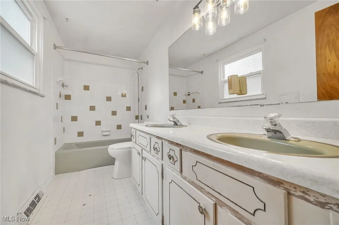 Full bathroom featuring bathtub / shower combination and double vanity