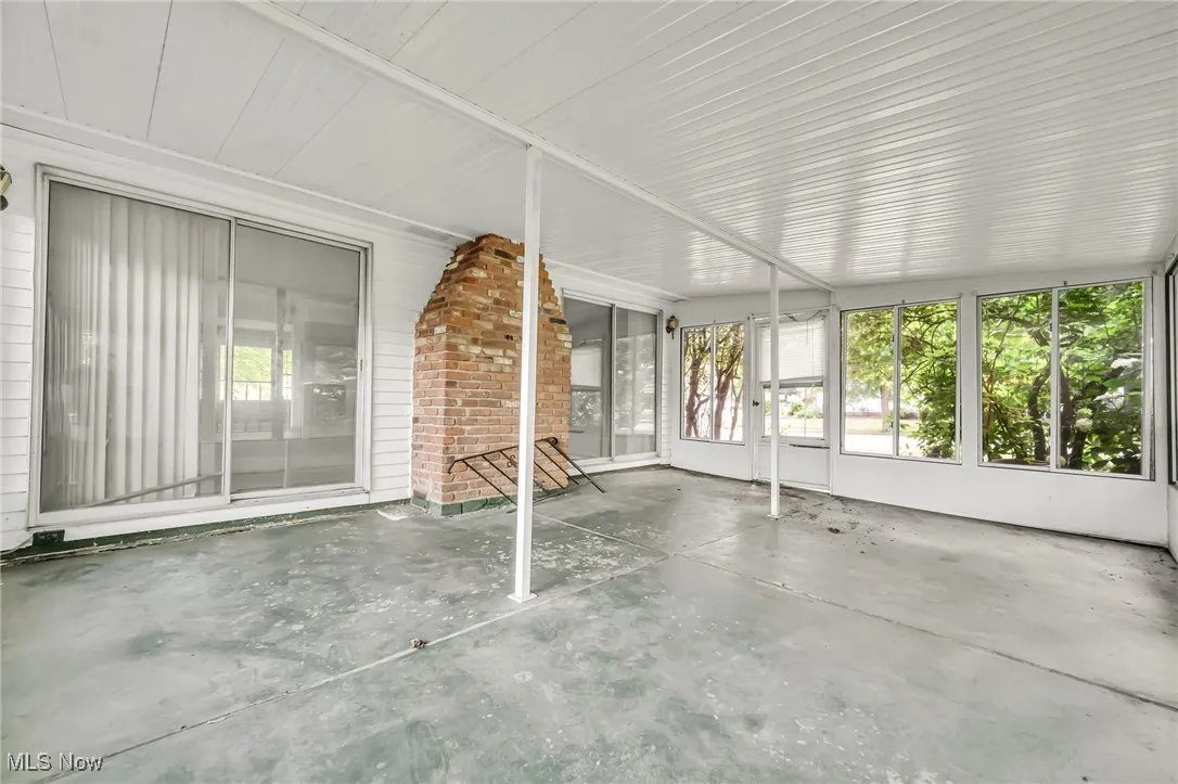 Unfurnished sunroom with unfinished concrete flooring