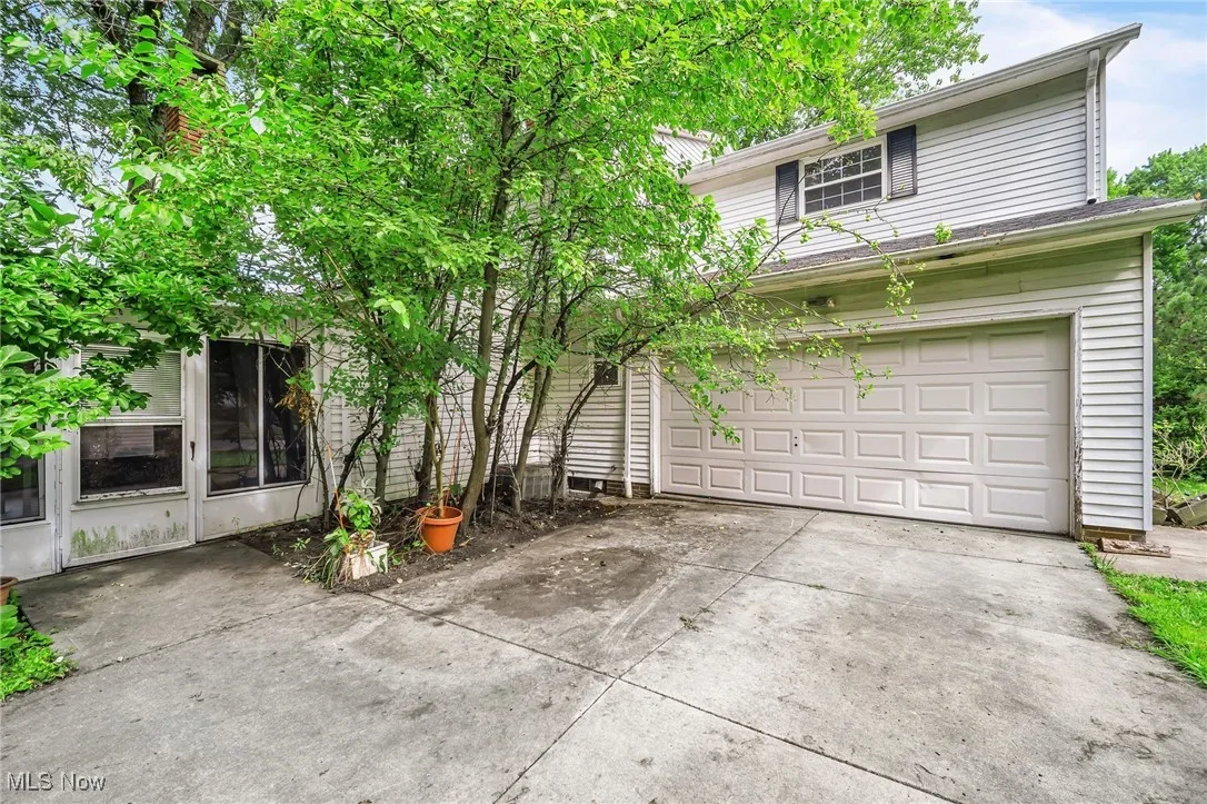 View of front facade featuring driveway and an attached garage