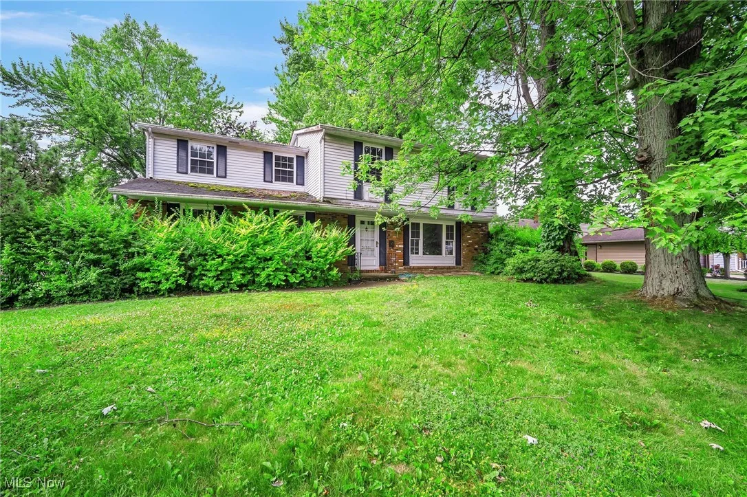 Traditional home with a front yard and brick siding