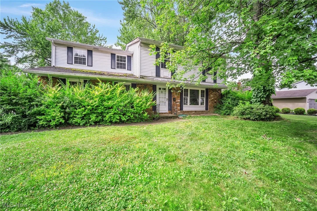 Traditional-style home with brick siding and a front yard