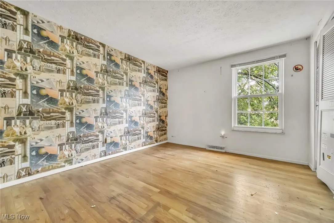 Spare room featuring a textured ceiling and wood finished floors