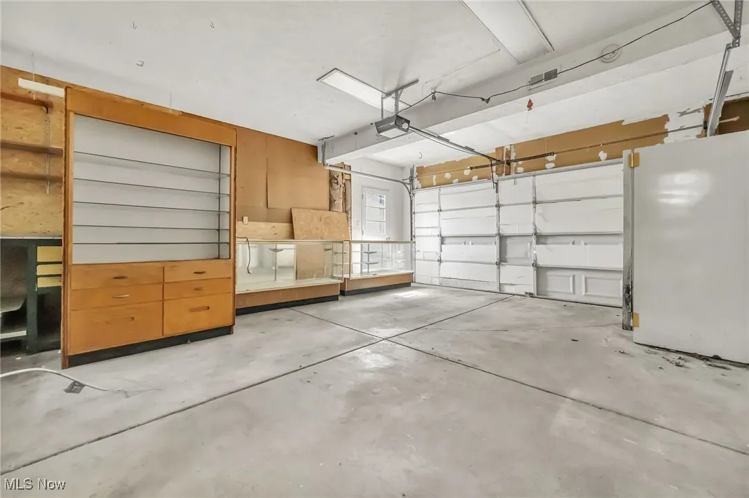 Garage with freestanding refrigerator and a garage door opener