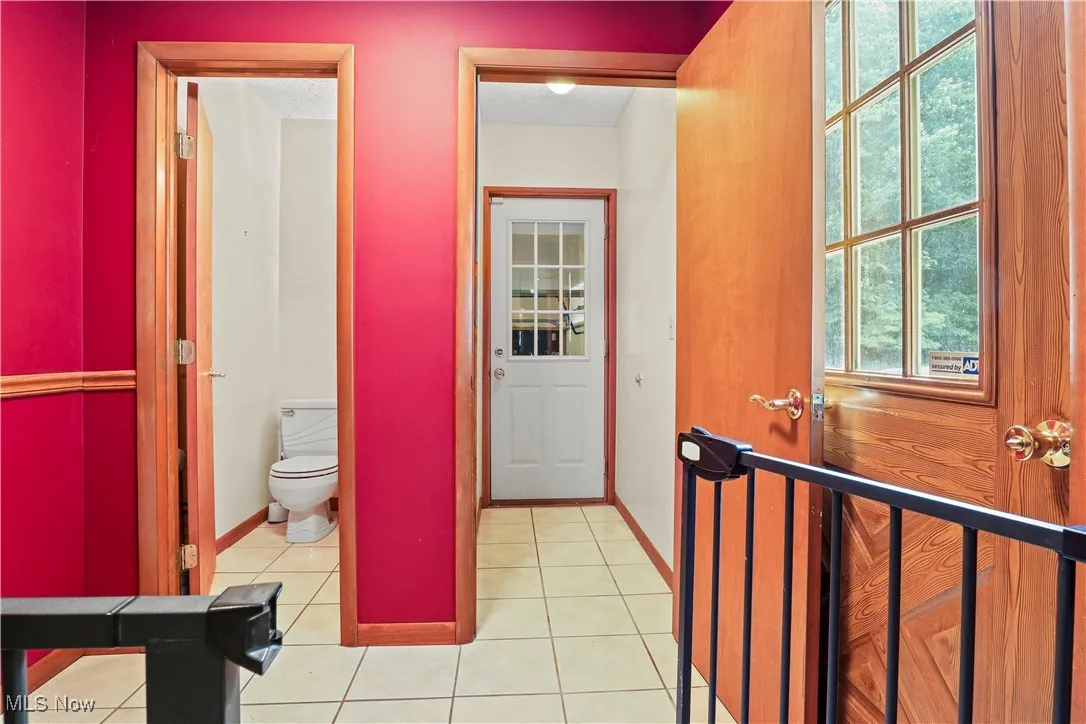 Main Floor Half Bathroom with attached mudroom, featuring tile patterned floors and plenty of natural light. Entrance from the garage or outside side of house.