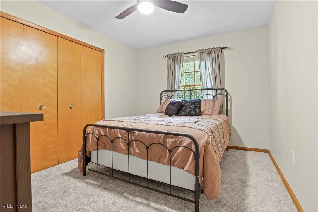 Carpeted bedroom featuring a closet and a ceiling fan