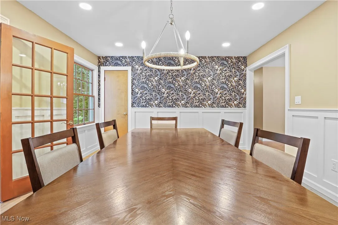Unfurnished dining area featuring a decorative wall, wainscoting, and recessed lighting