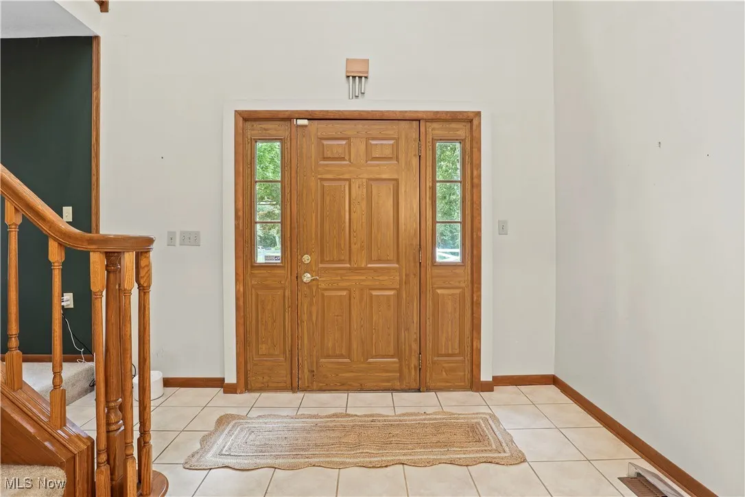Entrance two story 
foyer featuring stairway and light tile patterned floors