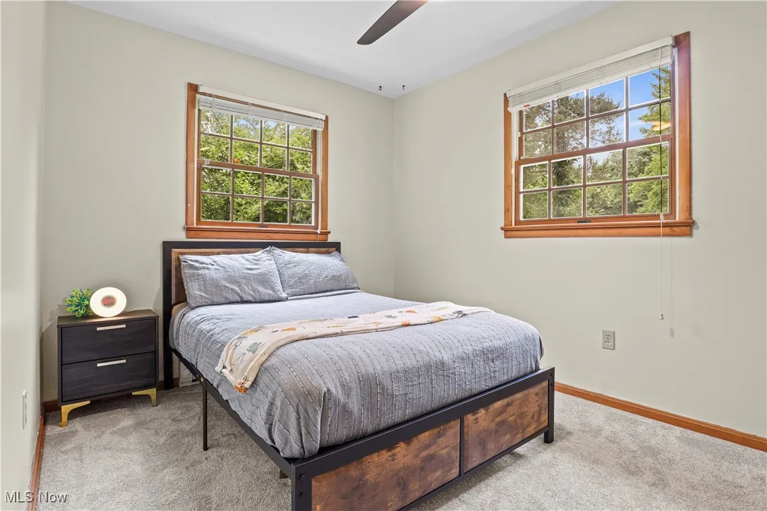 Carpeted bedroom featuring baseboards and a ceiling fan