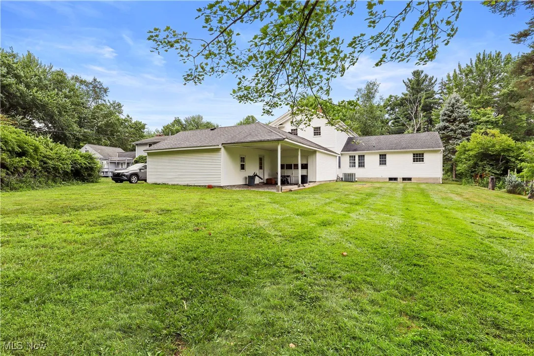 Rear view of house with a patio area and a yard
