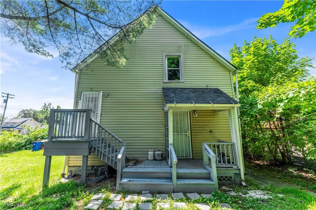 Back of house with a yard and roof with shingles