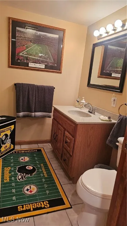 Half bathroom with vanity and tile patterned floors