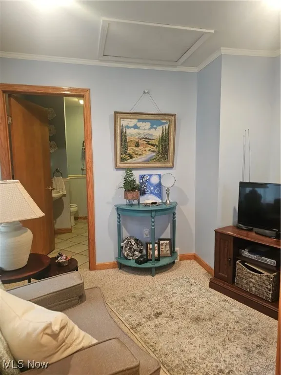 Sitting area featuring attic access and crown molding