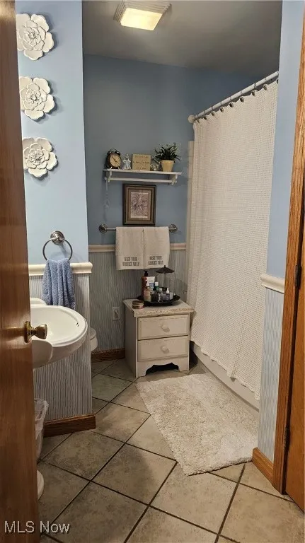 Bathroom with wainscoting and tile patterned floors