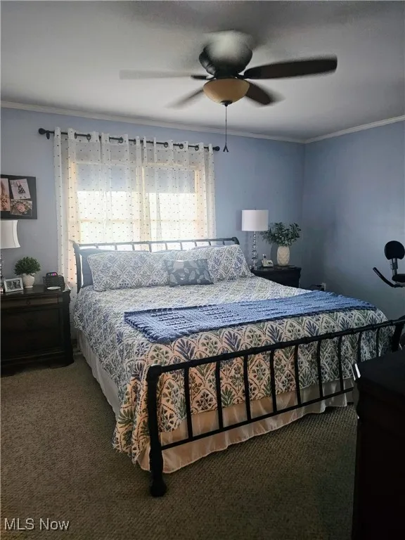 Bedroom featuring crown molding, carpet, and ceiling fan