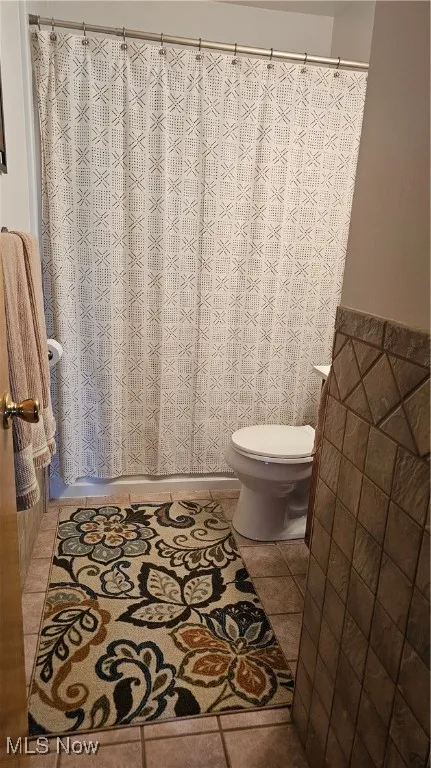 Full bathroom featuring curtained shower and tile patterned floors