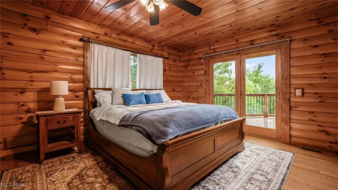 Bedroom with access to exterior, multiple windows, light wood-style floors, wood ceiling, and ceiling fan
