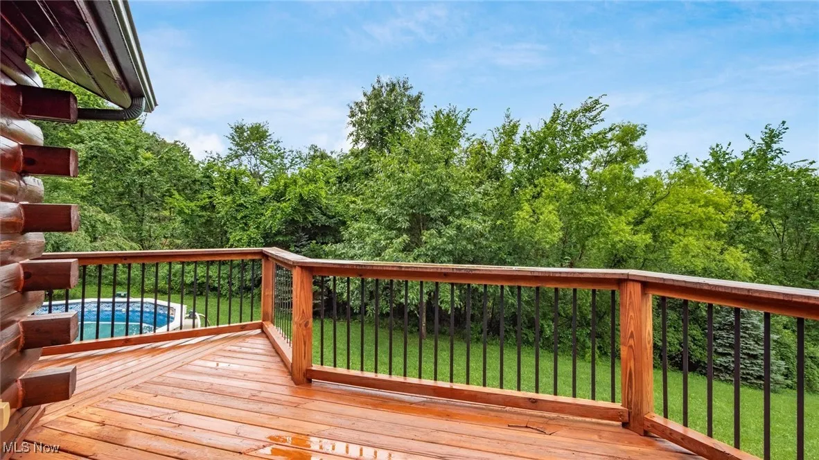 Wooden terrace featuring a yard and an outdoor pool