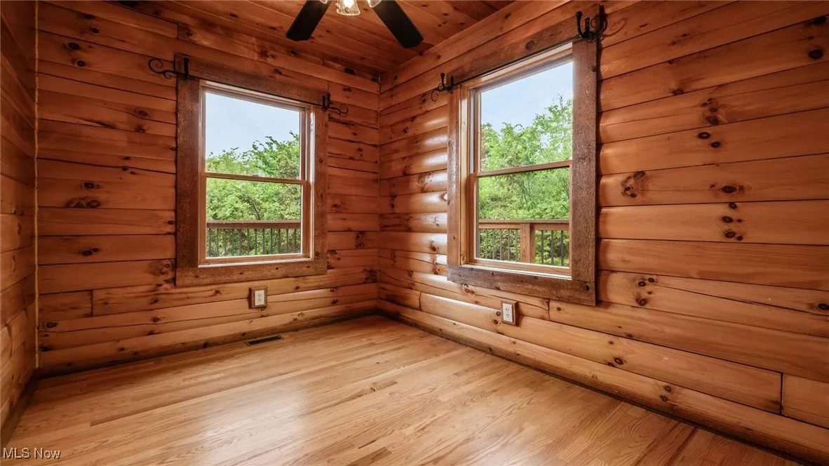 Spare room with light wood finished floors, healthy amount of natural light, ceiling fan, and wooden ceiling