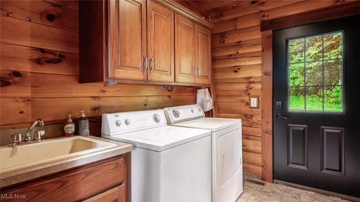 Laundry area featuring separate washer and dryer and cabinet space