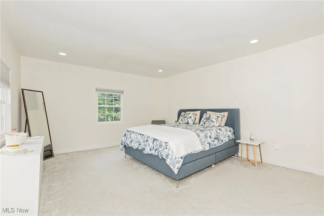 Attractive view showcasing the spacious primary suite, which has been recently updated with new, energy-efficient windows and plush, comfortable carpeting.