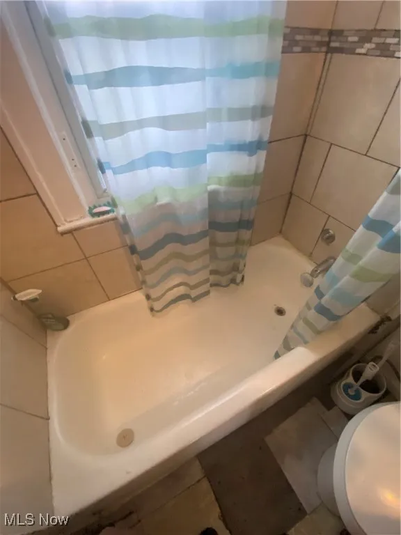 Full bathroom featuring toilet and shower / bath combo