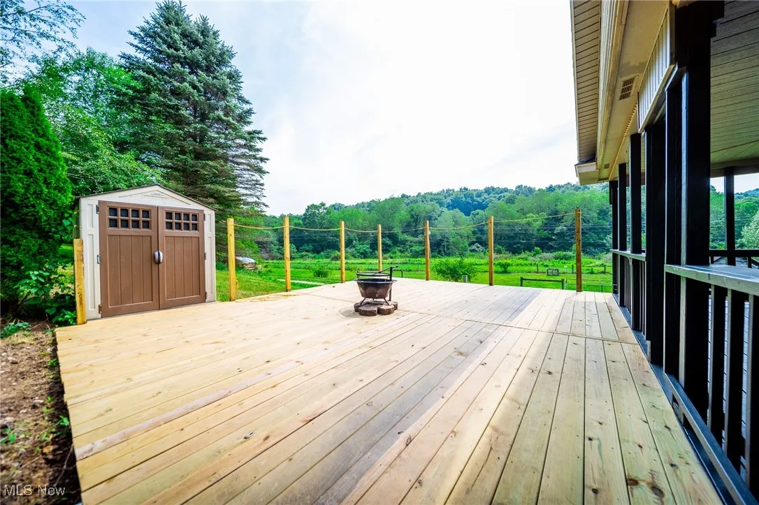 Wooden deck with a storage shed and a fire pit