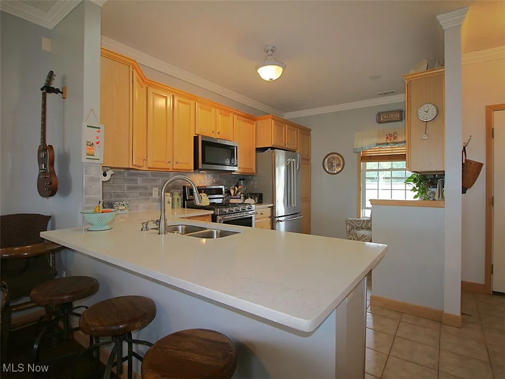 Kitchen with high- end appliances with built in desk opening into open concept dining/living area