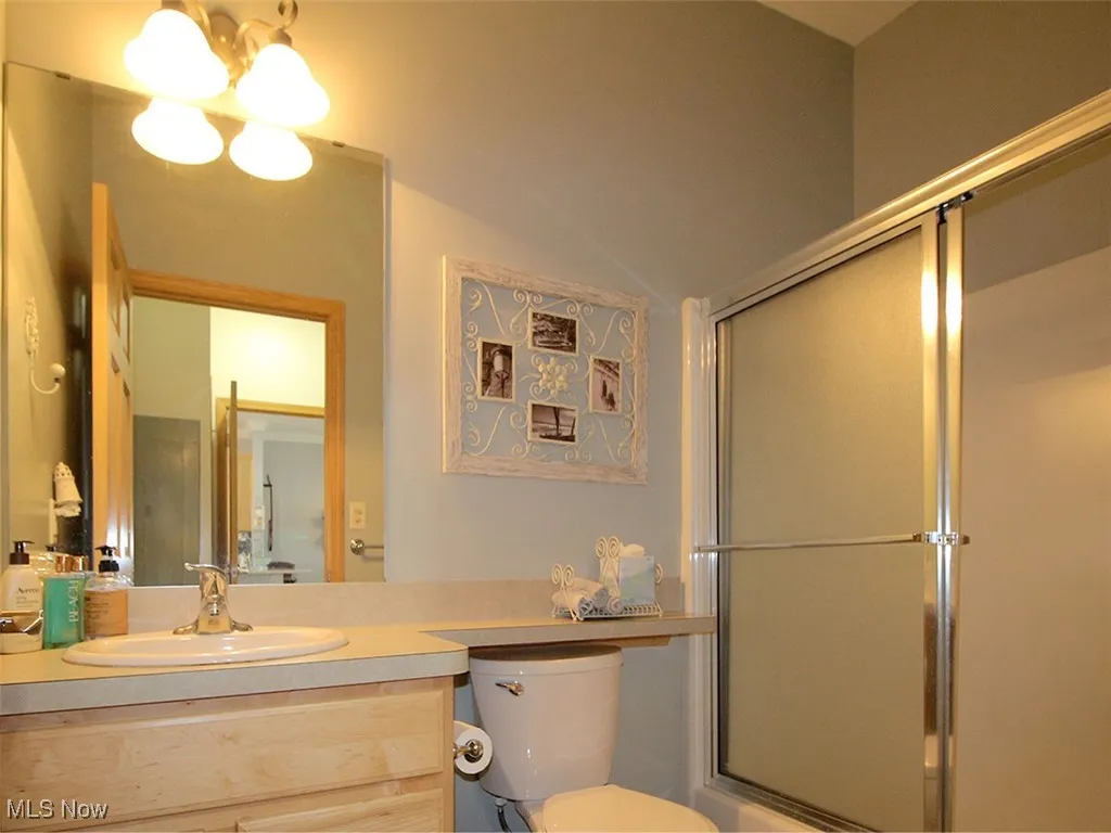 Bathroom with vanity, a shower with door