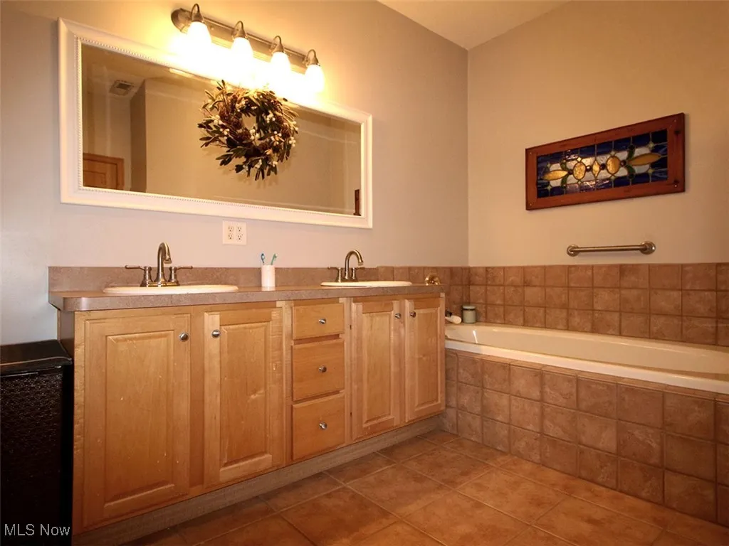 Owner's bath featuring double vanity and deep soaking tub
