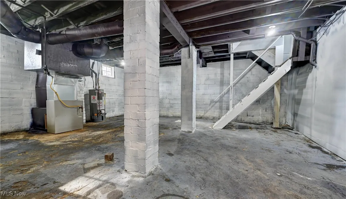 Below grade area featuring water heater and heating unit