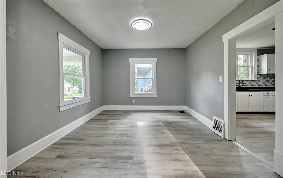 Empty room with healthy amount of natural light and light wood-type flooring