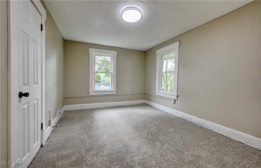 Carpeted empty room featuring healthy amount of natural light