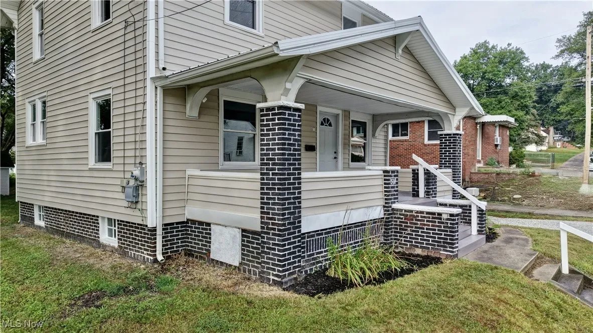View of side of property featuring covered porch