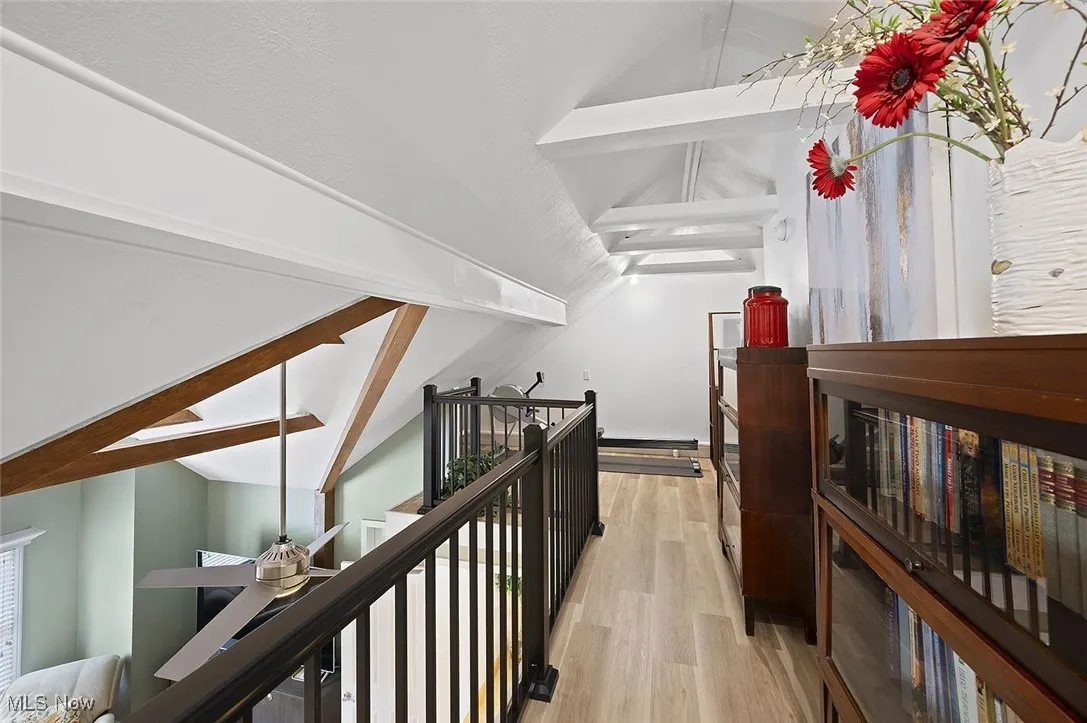 Hall with an upstairs landing and light wood-style flooring