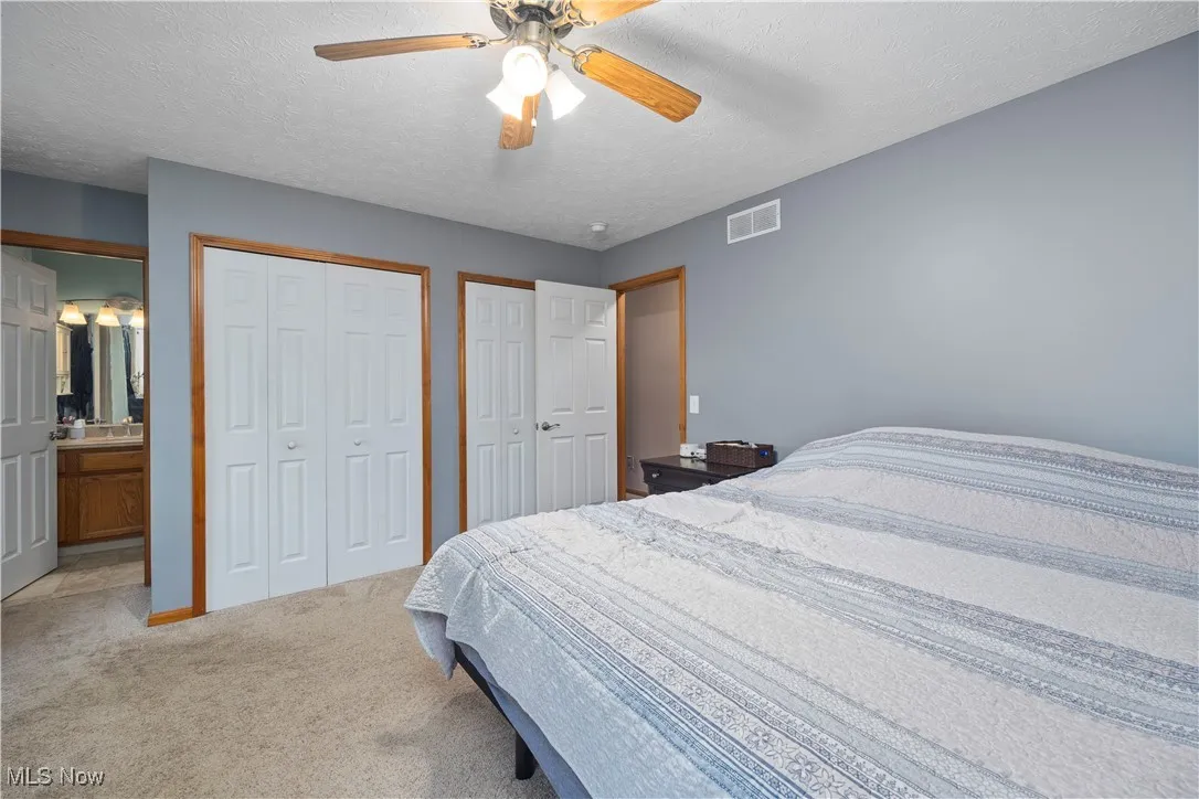 Master bedroom featuring 2 closets and full bathroom