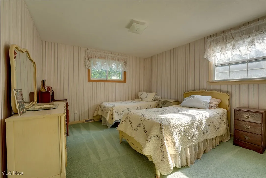 Bedroom featuring light carpet and wallpapered walls
