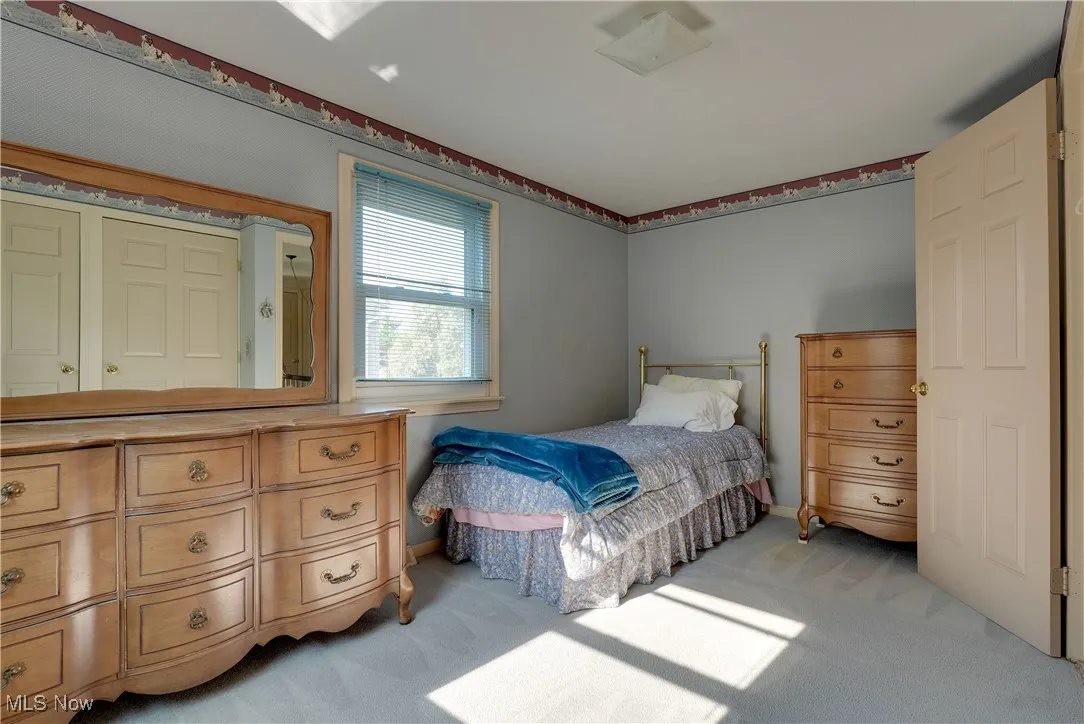 Bedroom with light colored carpet and baseboards