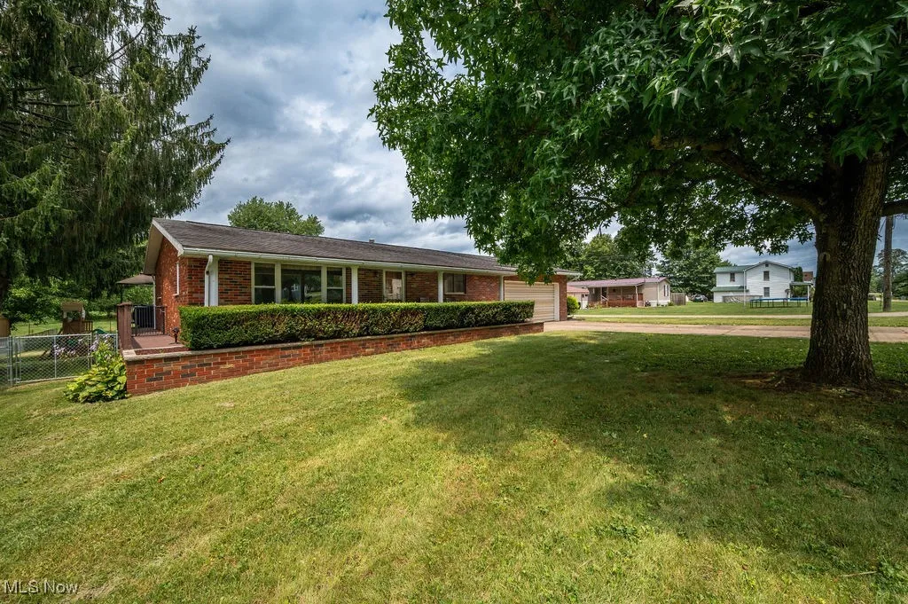Ranch-style house featuring an attached garage, driveway, and brick siding